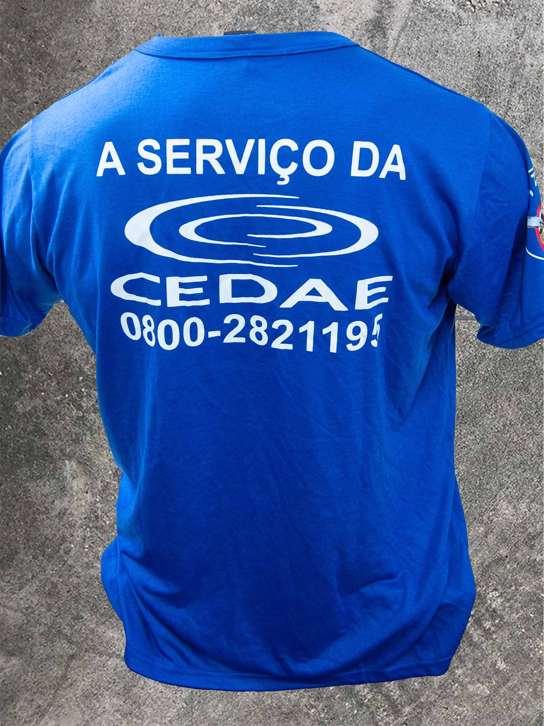Costas de camiseta azul A serviço da CEDAE